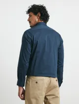 Camisa de manga larga con cuello button-down y bolsillo frontal. Confeccionada en tejido con elastano para mayor comodidad y libertad de movimiento.