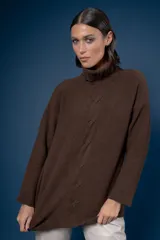 Buzo de cuello alto tejido en lana, con diseño de ochos en el centro y mangas largas con hombros caídos.