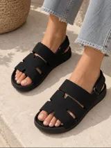 Sandalias de gamuza color beige con tiras anchas, aberturas laterales y tira en el talón con cierre ajustable.
