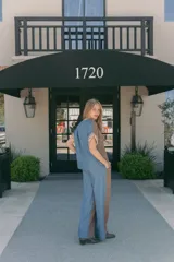 Blusa marrón con cuello en V, mangas cortas con detalle de tela rayada en los puños y corte holgado.