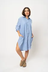 Vestido camisero corto color crema a rayas verticales finas, con cuello camisero, cierre frontal con botones y mangas largas con puños abotonados.