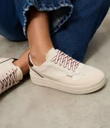Championes casuales Satinato de diseño urbano, confeccionados en poliuretano con recortes superpuestos y costuras visibles. Presentan puntera redondeada con microperforaciones, suela alta de goma, refuerzo trasero en color contrastante y cordones con diseño diferenciado.
