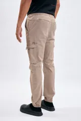 Pantalón cargo tipo jogger color tostado, de corte relaxed con bolsillos laterales con solapa en las piernas y puños elásticos en los tobillos.