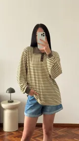 Buzo de morley a rayas horizontales color verde y beige, con cuello polo y mangas largas. Cuello y puños en tejido liso color marrón.