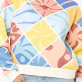 Buzo de cuello redondo con diseño de rombos estampados en tonos pasteles, con puños y cintura en color crema. Presenta un corte relajado y logo de la marca bordado en el pecho.