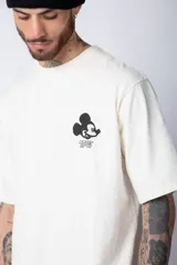 Remera negra de corte oversize confeccionada en algodón pesado, con estampa pequeña de Mickey Mouse en el pecho y diseño gráfico en la espalda.