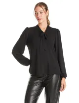 Blusa de seda fría color negro, con escote en V y lazo decorativo al cuello. Presenta mangas largas abullonadas con puños elásticos y detalles de strass aplicados en cuello, lazo y mangas.