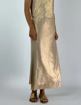 Conjunto plateado brillante de top con breteles finos y pollera larga con efecto mojado.