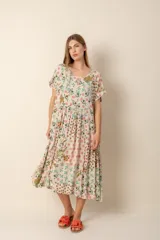 Vestido largo estampado con motivos florales y geométricos en tonos pastel, con escote redondo, mangas cortas y falda con volados.