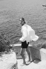 Shorts de denim azul oscuro, tiro alto, con cierre de botón dorado. Los bolsillos delanteros tienen un detalle de ribete trenzado.