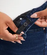 Pantalón de jean skinny azul oscuro, con elástico regulador interno, cinturilla con trabillas, botón, bolsillos y sin estampado.