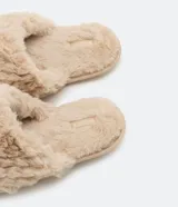 Pantufla cerrada de mujer con textura de peluche suave en color negro, diseñada para brindar comodidad en el hogar.