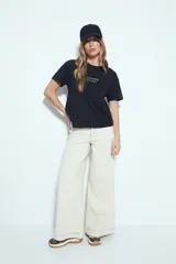 Remera blanca de manga corta con cuello redondo, aberturas laterales y bordado frontal con la frase "LIMITED EDITION" en negro.