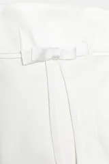 Vestido corto de escote recto y hombros descubiertos, con detalle de lazo en el delantero. Cuenta con forro interior y cierre de cremallera oculta en la espalda.