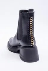 Bota de caña media color marrón con pieza elastizada en los laterales, detalle metálico atrás y plataforma de 6cm de alto.