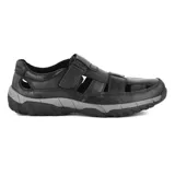 Sandalia casual de cuero negro con aberturas laterales y ajuste con velcro. Suela de goma con diseño antideslizante en color gris.
