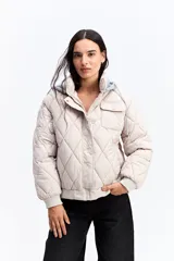 Campera puffer negra con diseño matelaseado en rombos, capucha integrada, cierre frontal y puños elásticos.