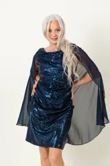 Vestido de fiesta azul con lentejuelas y capa de gasa transparente.