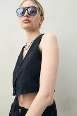 Chaleco crop top negro de denim con ajuste frontal con cordones.