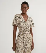Mono largo de viscosa con estampado animal print jaguar, escote en V, cierre frontal con botones, mangas cortas, cintura con lazo ajustable y bolsillos laterales.