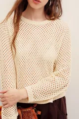 Sweater de punto calado color beige con hilos de lurex, de corte recto, manga larga y cuello redondo con terminación elástica acanalada.
