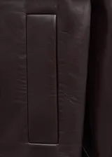 Abrigo de cuero ovino con cuello solapa extragrande, cierre frontal con cremallera y diseño de corte holgado.