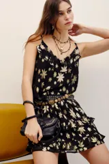 Falda short negra con estampado floral metalizado en tono dorado, de tiro alto y diseño con volados escalonados.