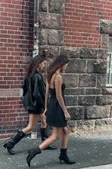 Vestido corto de corte ajustado con escote tipo bustier y tirantes finos. Presenta costuras verticales que definen la silueta y cierre posterior con cremallera oculta.