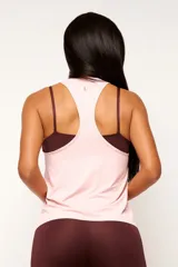 Musculosa deportiva blanca de corte holgado, con espalda estilo nadador y logo pequeño en el ruedo.