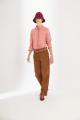 Pantalón de gamuza color marrón, de tiro medio y corte slouchy. Presenta bolsillos laterales y traseros, cierre metálico frontal y forro interno con stretch.