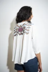 Blusa color crudo con bordado multicolor en los hombros, cuello mao y mangas 3/4.