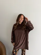 Canguro negro de terciopelo, de corte oversize y manga larga, con capucha y detalle de parche bordado en la manga.