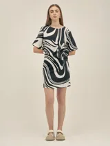 Top de escote redondo y manga corta, con estampado abstracto en blanco y negro. Presenta un corte asimétrico en la espalda y está confeccionado en lino viscosa.