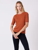 Buzo tejido marca Tahari, color verde, con cuello a la base, manga corta y diseño de ochos en el frente.