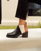 Botines Chelsea de cuero, color negro, con detalles en cuero marrón texturizado (tipo cocodrilo) y paneles laterales en color beige claro. Tienen un taco ancho y cuadrado, y cierre de cremallera lateral en color beige.