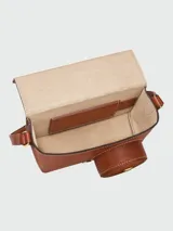 Cartera bandolera Longchamp modelo Épure en formato cámara XS, color marrón coñac, con correa fina ajustable y cierre superior.