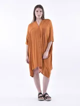 Vestido midi de corte holgado y diseño oversize, color naranja, con cuello en V, cierre frontal con botones y mangas cortas amplias.