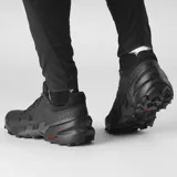 Championes Salomon Speedcross 6 de color negro, diseñados específicamente para trail running. Presentan una estructura robusta y técnica, capellada sintética y textil con refuerzos termosellados, sistema de cordones de ajuste rápido Quicklace y suela con tacos profundos para máxima tracción en terrenos difíciles.