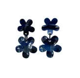Aros colgantes con forma de dos flores superpuestas, hechas de resina marmolada en tonos azul y blanco.