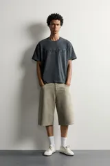 Camiseta relaxed fit de manga corta y cuello redondo, color gris oscuro, con estampado en relieve tono sobre tono con la palabra 'MODULE' en el frente.