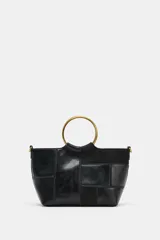 Bolso tipo saca en formato mini con diseño de patchwork en tonos marrones. Cuenta con una anilla metálica rígida como asa de mano y una correa bandolera extraíble. El cierre principal es mediante imán e incluye un bolsillo interior con cremallera.