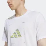 Remera deportiva Adidas de manga corta y cuello redondo, color blanco, con un logo grande estampado en el pecho que combina el logo performance con un patrón de camuflaje en tonos verde lima y amarillo.