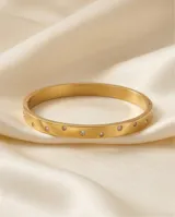 Pulsera tipo esclava rígida de acero con baño de oro, decorada con circonias incrustadas a lo largo de toda la pieza.