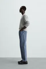 Jersey color crudo de tejido de punto, con cuello redondo y mangas largas. Corte amplio y terminaciones en rib.