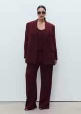 Americana de corte recto y diseño estructurado en color bordó. Presenta cuello con solapas de muesca, cierre frontal con botón, bolsillos laterales con solapa y un bolsillo de ribete en el pecho. Incluye forro interior completo y mangas largas.