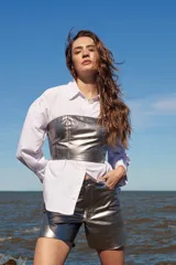 Top tipo corset plateado de cuero ovino, con tirantes finos regulables y cierre trasero con cremallera.