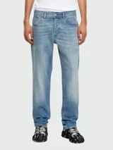 Pantalón de jean Diesel modelo D-Finitive, de corte recto, color celeste con lavado claro y detalles de desgaste. Tiene bolsillos delanteros y traseros, cierre con botón y cremallera, y etiqueta de la marca en el bolsillo trasero.