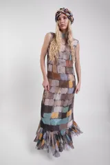 Vestido largo sin mangas de tela calada con estampado estilo patchwork multicolor, cuello alto y volados en el ruedo.