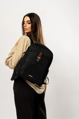 Mochila negra de tela impermeable con detalles en cuero marrón.