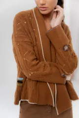 Saco tejido de lambswool color marrón, con diseño inspirado en kimono, mangas largas y delicados calados en toda la prenda. Cuenta con bordes en contraste.